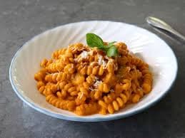 Plate of fusilli pasta with tomato sauce and basil